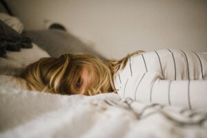 Tired woman lying in bed unable to feel rested despite sleeping